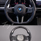 Carbon fiber heated performance steering wheel installed on a 2018-2024 BMW X1/X2 (F39), 5 Series (G30/G31), X3 (G01), X5 (G05), X6 (G06), X7 (G07), or M3 (G80)