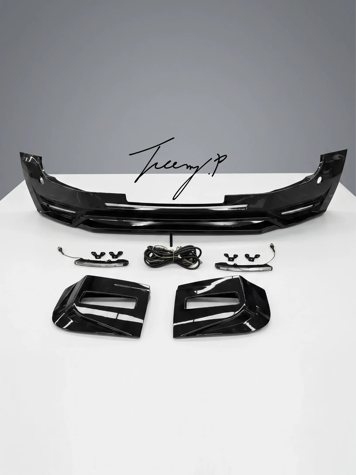 Gloss black front bumper splitter lip spoiler body kit installed on a 2020-2025 Land Rover Defender L663 90 / 110