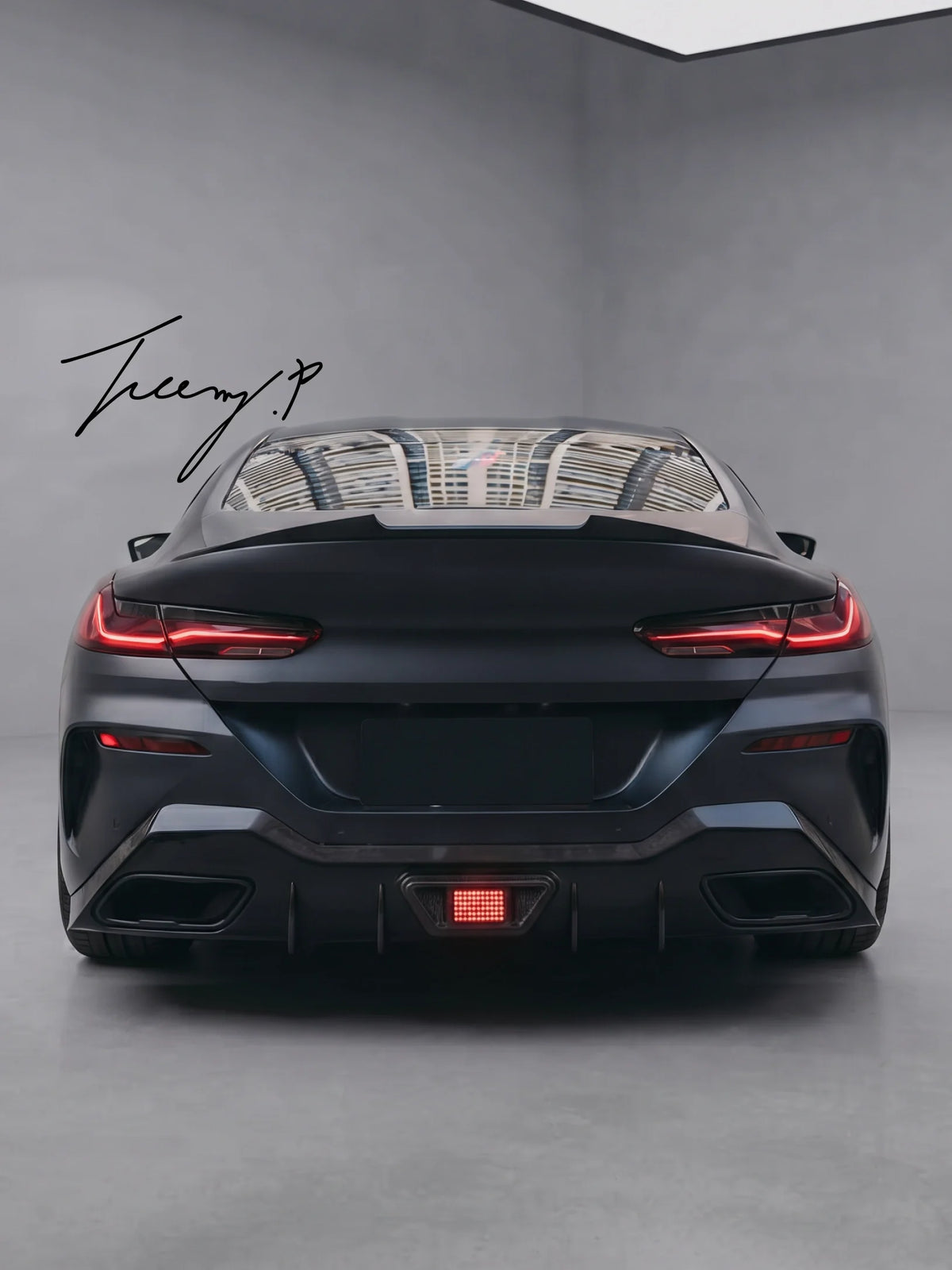Gloss black rear bumper diffuser with integrated center LED light on a BMW 8 Series G16 Gran Coupe