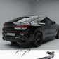Gloss black rear bumper diffuser, lip splitters, and body kit installed on a 2019-2023 BMW X6 G06